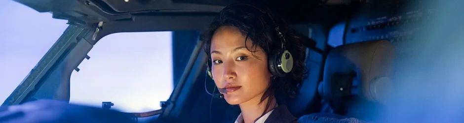 Young female Asian Aviation student in cockpit with headset and microphone