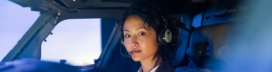Aviation Scholarships Young female Asian Aviation student in cockpit with headset and microphone